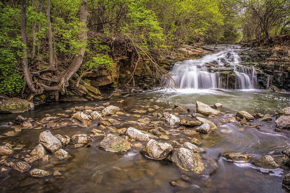 Waterfall and rocky stream surrounded by spring greenery at Farrington Reserve in Miami County, near Piqua, Ohio